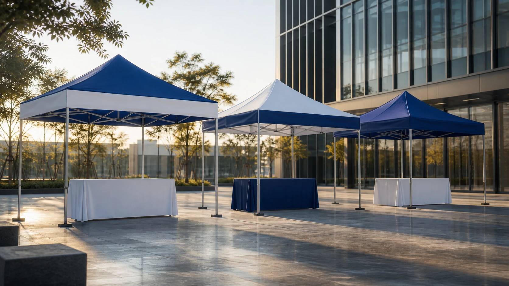 A coordinated group of unbranded blue and white pop-up canopies in a modern outdoor event space.